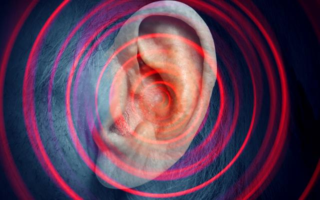 Foto van een oor. Er zijn cirkels van klein naar groot overheen afgebeeld, om geluid weer te geven.