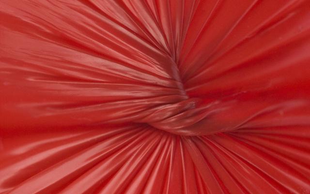 Een knoop in rood, latexachtig materiaal.