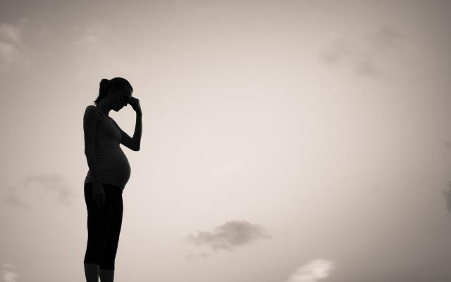 Silhouet van een mens met een zwangere buik.