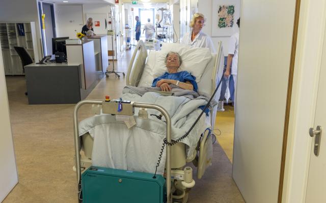 Een oudere patiënt in een ziekenhuisbed.