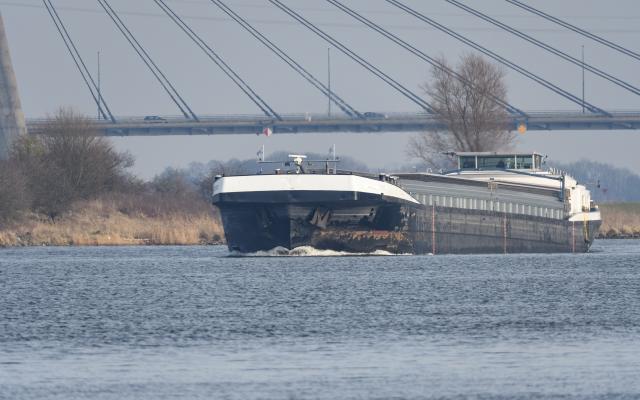 Vrachtschip vaart onder een brug door.