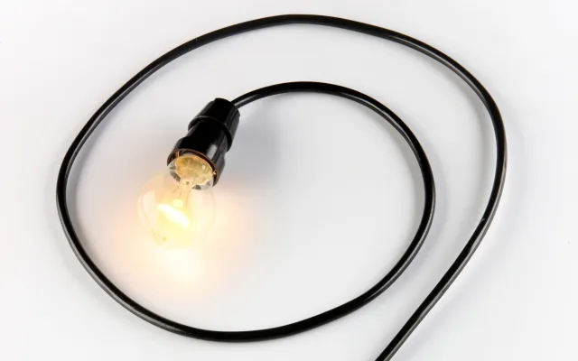 Een lamp waarvan het snoer de vorm van een vraagteken heeft.