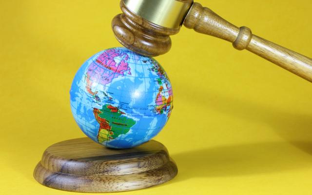 Een kleine globe onder een voorzittershamer.