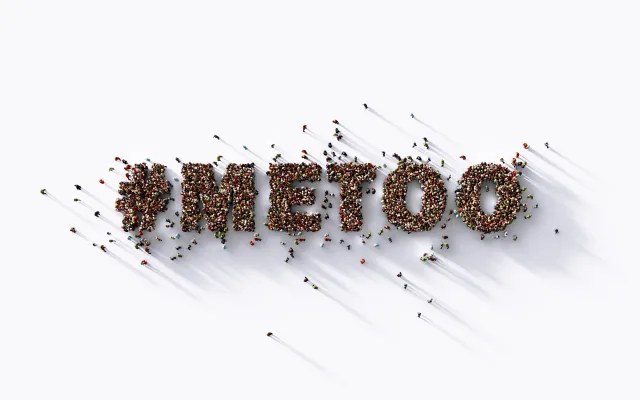 Een massa mensen vormt van bovenaf de hashtag #METOO.