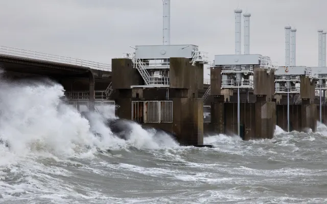 Foto van de Oosterscheldekering. Het water heeft hoge golven.