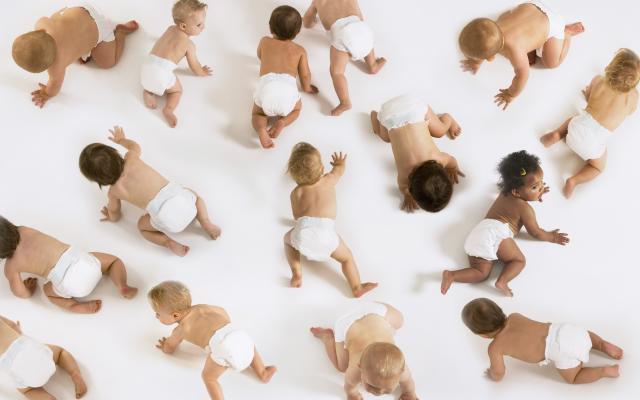 Een aantal babies kruipt over de vloer.