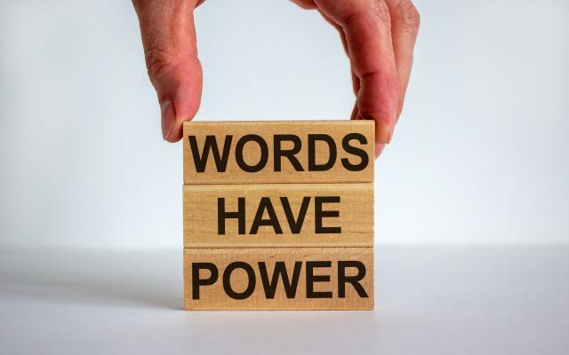 Drie op elkaar gestapelde blokken met de woorden: "Words have power".
