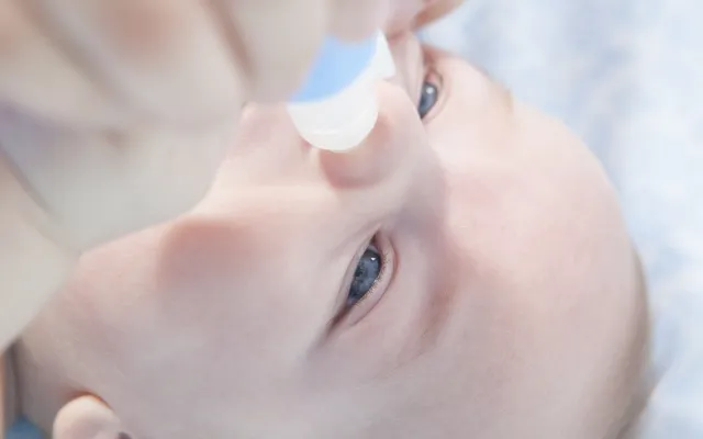 Een baby krijgt een neustoilet.
