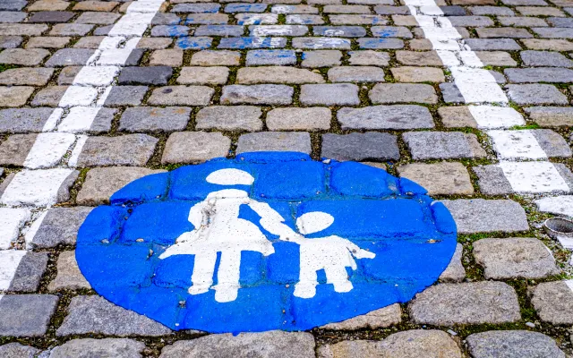 Blauw-wit icoon van een moeder met kind. Het icoon is geverfd op straattegels.