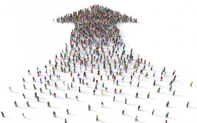 Een massa mensen vormt samen een pijl.