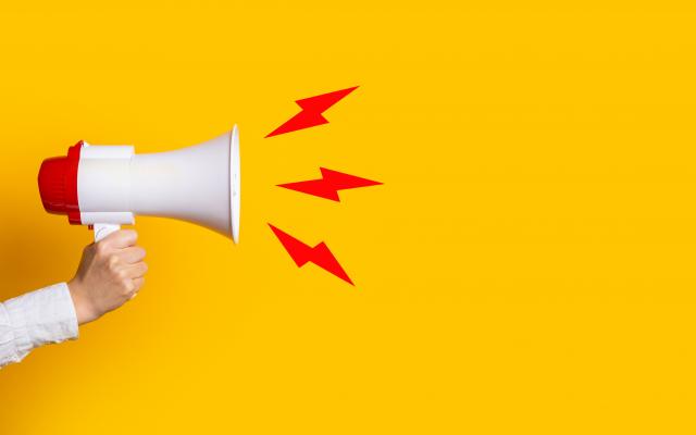 Megafoon vastgehouden door een arm met drie bliksemschichten uit de megafoon.