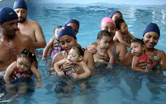 Zwemmende kinderen met hun ouders