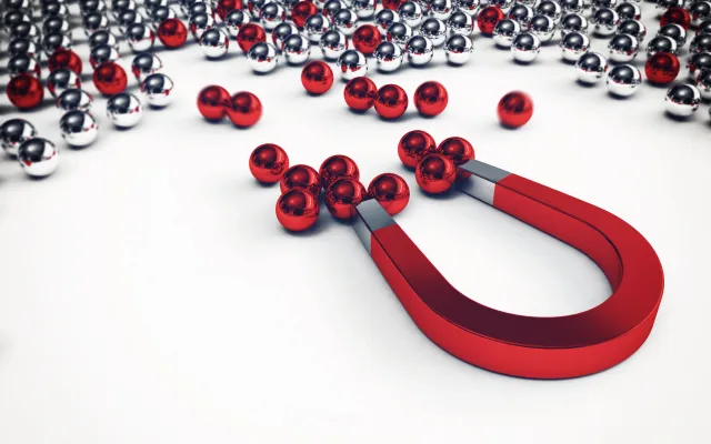 Foto: alphaspirit.it/shutterstock Een magneet die rode en zilveren bolletjes aantrekt