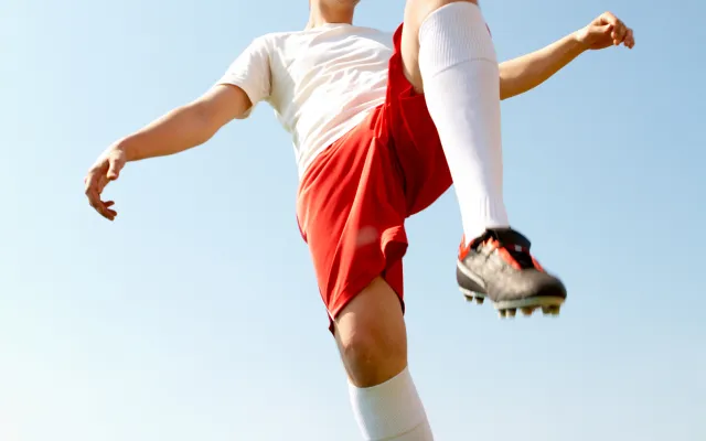 Kind met voetbal op de knie