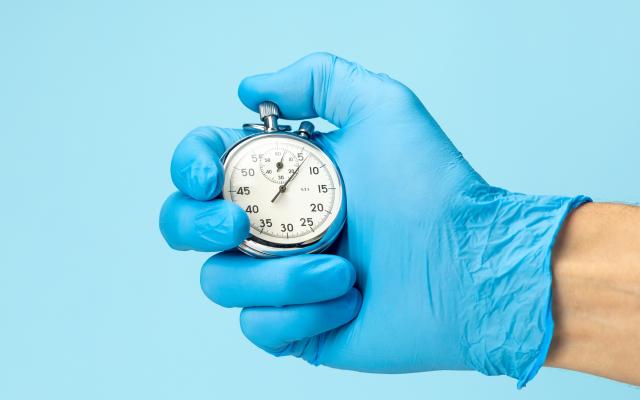 Gehandschoende hand met stopwatch