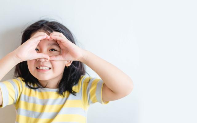 Meisje dat met haar handen een bril voor haar ogen maakt