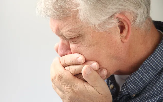 Man die zijn hand voor de mond houdt
