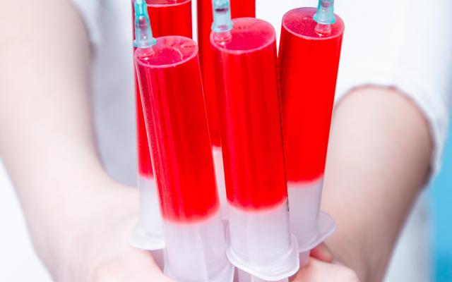 Handjevol injectiespuiten met rode vloeistof