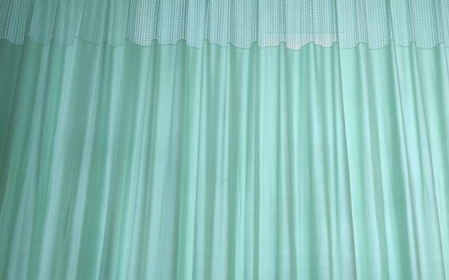 Licht schijnt door dunne gordijnen.