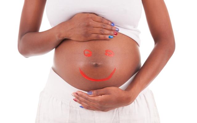 zwangere vrouw met smiley op buik.