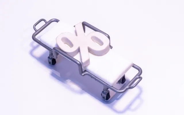 Foto: norrie3699/iStock.com Illustratie van een brancard met een procentteken erop