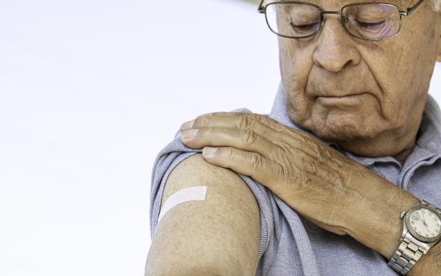 Oudere man met een pleister op z'n arm