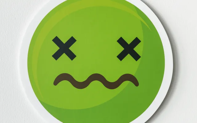 Een groene smiley met kruizen als ogen en een golvende mond