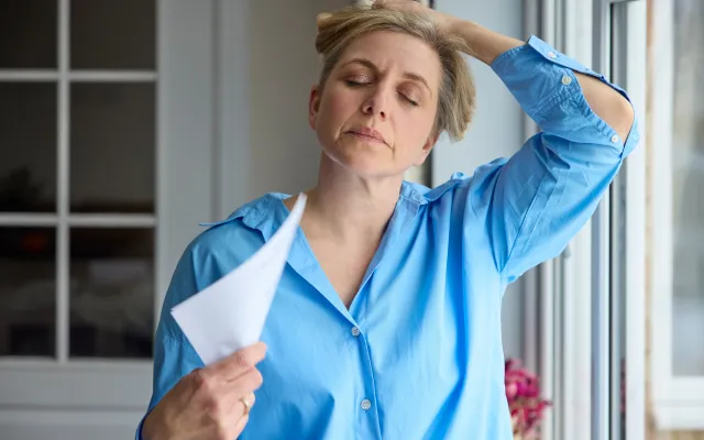 Foto: SpeedKingZ/shutterstock Vrouw met ogen dicht en hand op haar hoofd