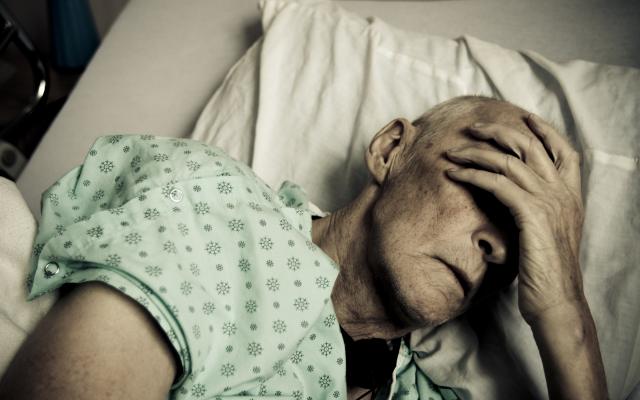 Oude man in ziekenhuisbed