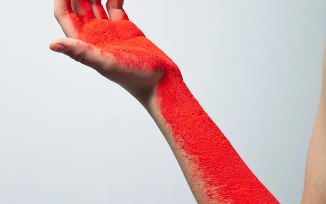 Foto van een arm met rode inkt