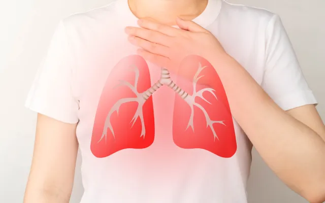 Iemand met wit T-shirt met rode longen erop