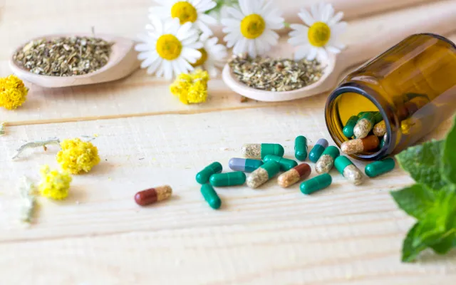 Beeld: Mary Mudr/Shutterstock Bloemen, kruiden en pillen op een tafel