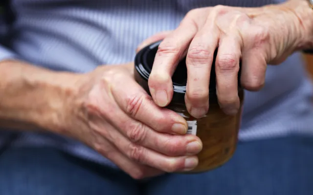 Beeld: bloodstone/iStock.com Handen die proberen een pot open te maken