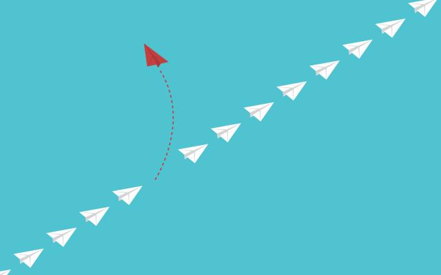 Een rij witte pijlen waarvan er een rode de andere kant opgaat