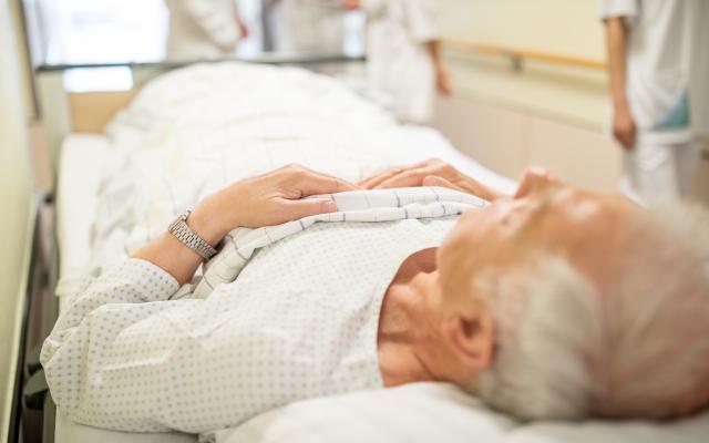 Oude man die in zieknhuisbed ligt