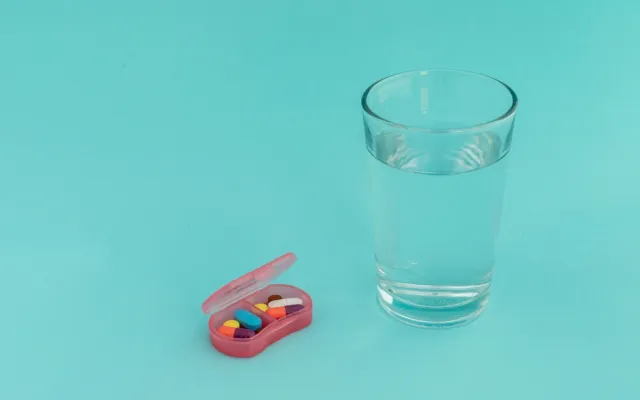 Glas water met een pillendoosje