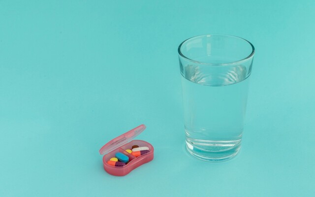 Glas water met een pillendoosje