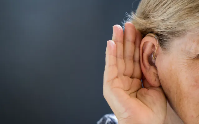 Iemand die een hand bij het oor houdt