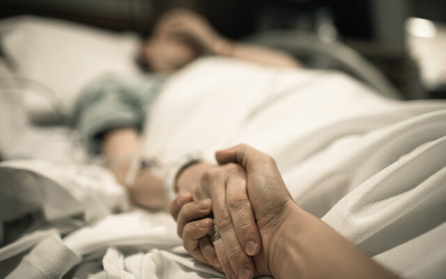 Iemand die de hand van een patiënt vasthoudt 