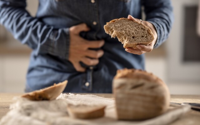 Iemand met brood in zijn hand die buik vasthoudt