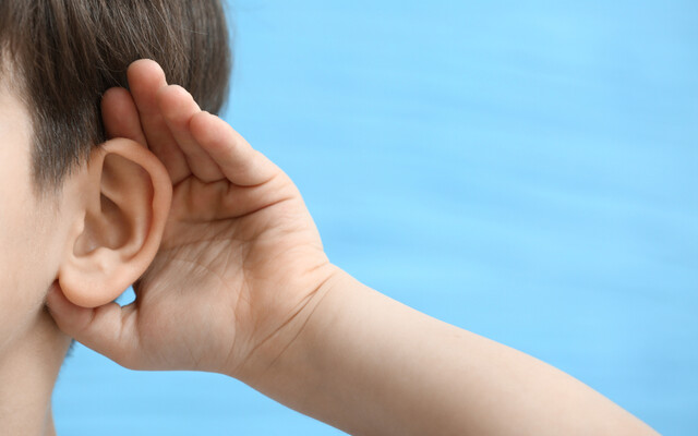 Kind met hand achter het oor