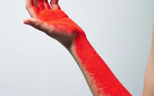 Arm bedekt met rood poeder