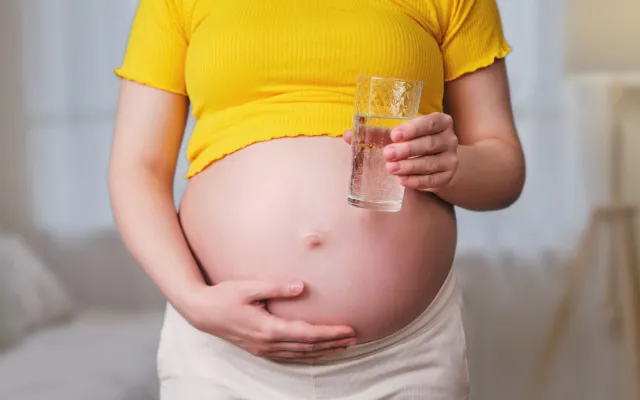 Zwangere vrouw met glas water 