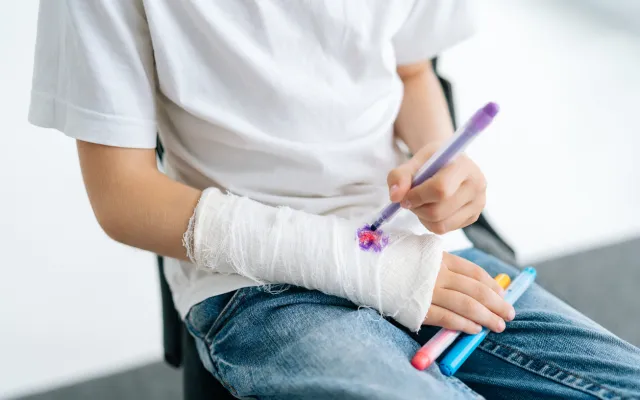 Iemand die tekent op zijn gips