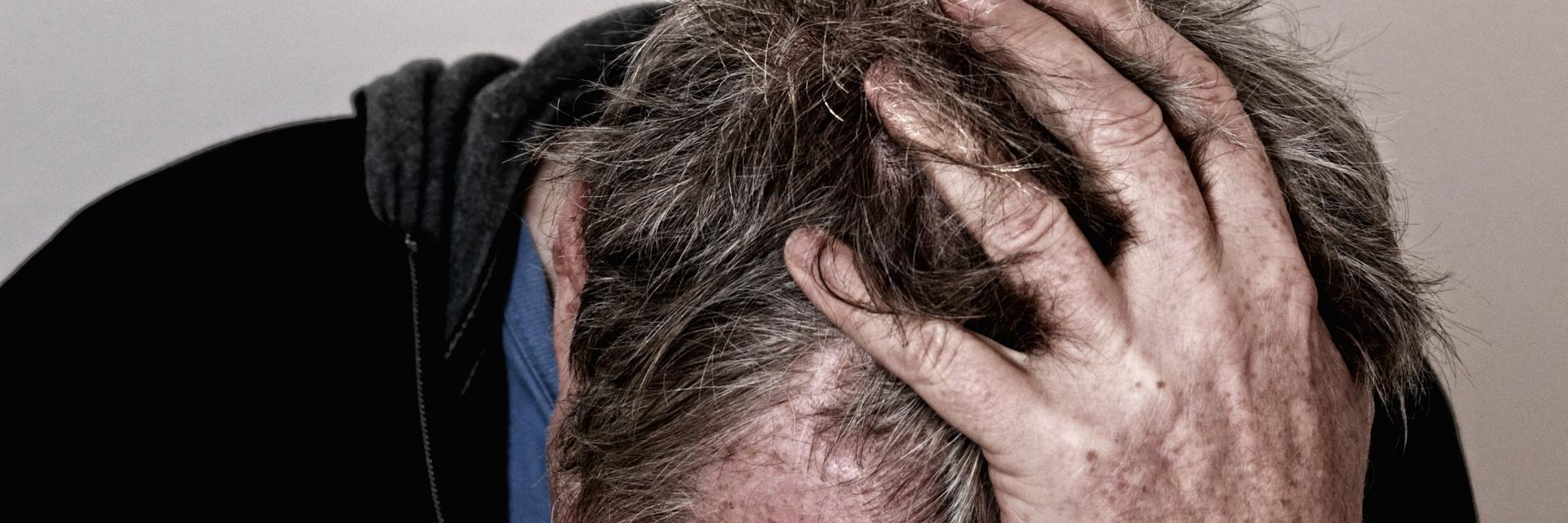 Man met zijn hand in z'n haar.