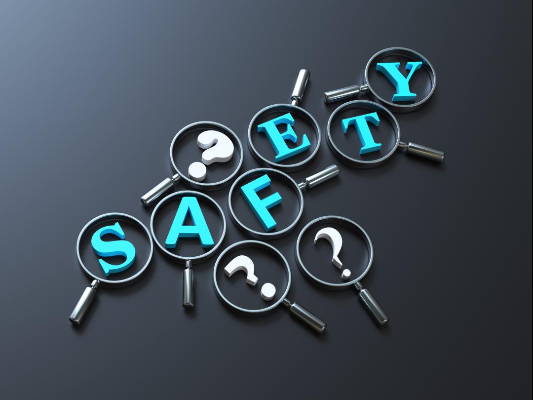 Het woord 'Safety' omringd door vraagtekens. Op elke letter en vraagteken ligt een vergrootglas.