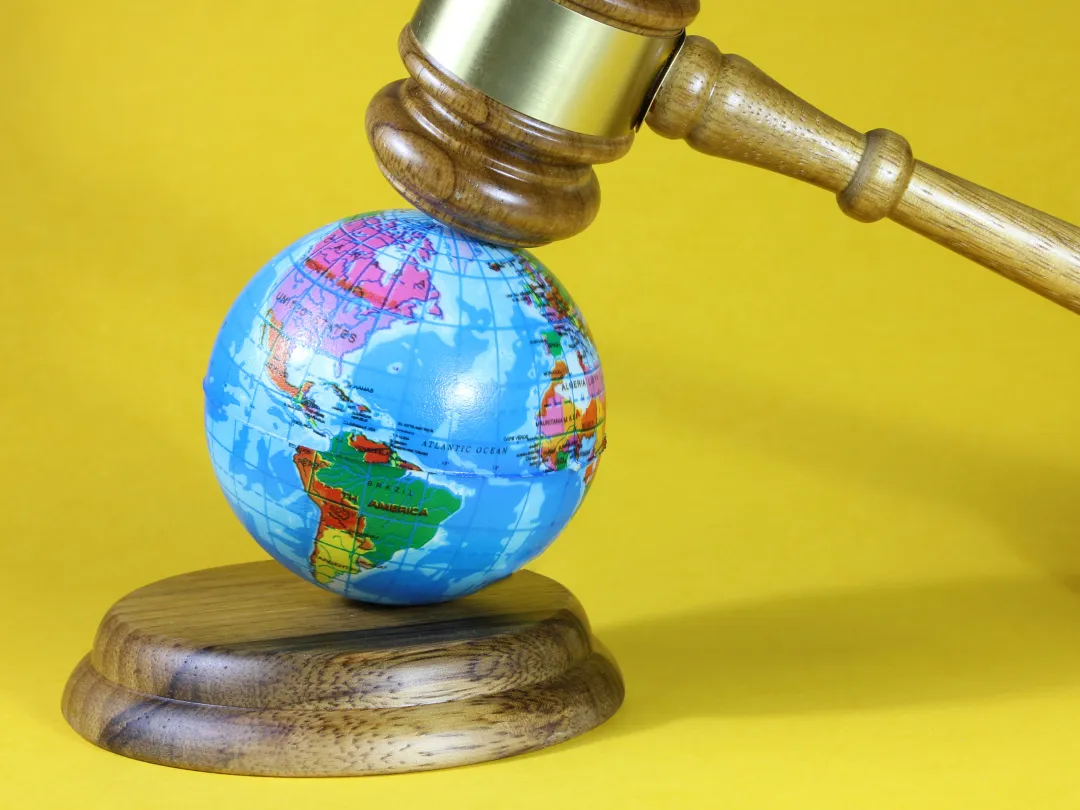 Een kleine globe onder een voorzittershamer.