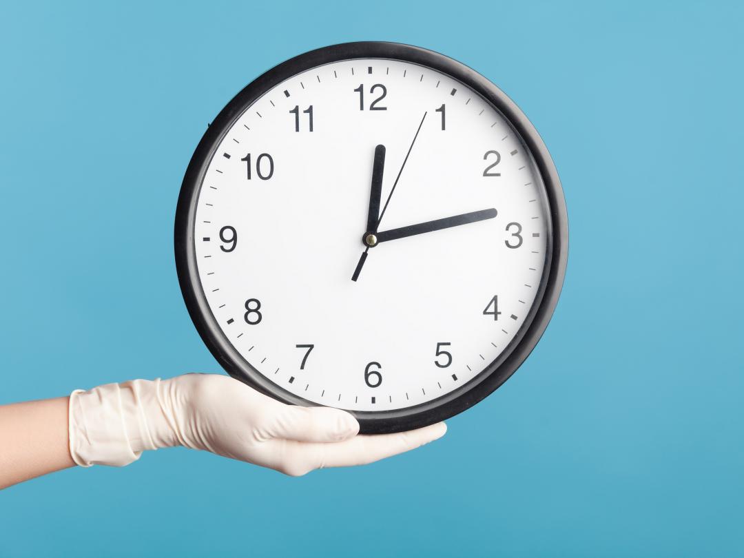 Een klok wordt gedragen door een hand met een witte handschoen.