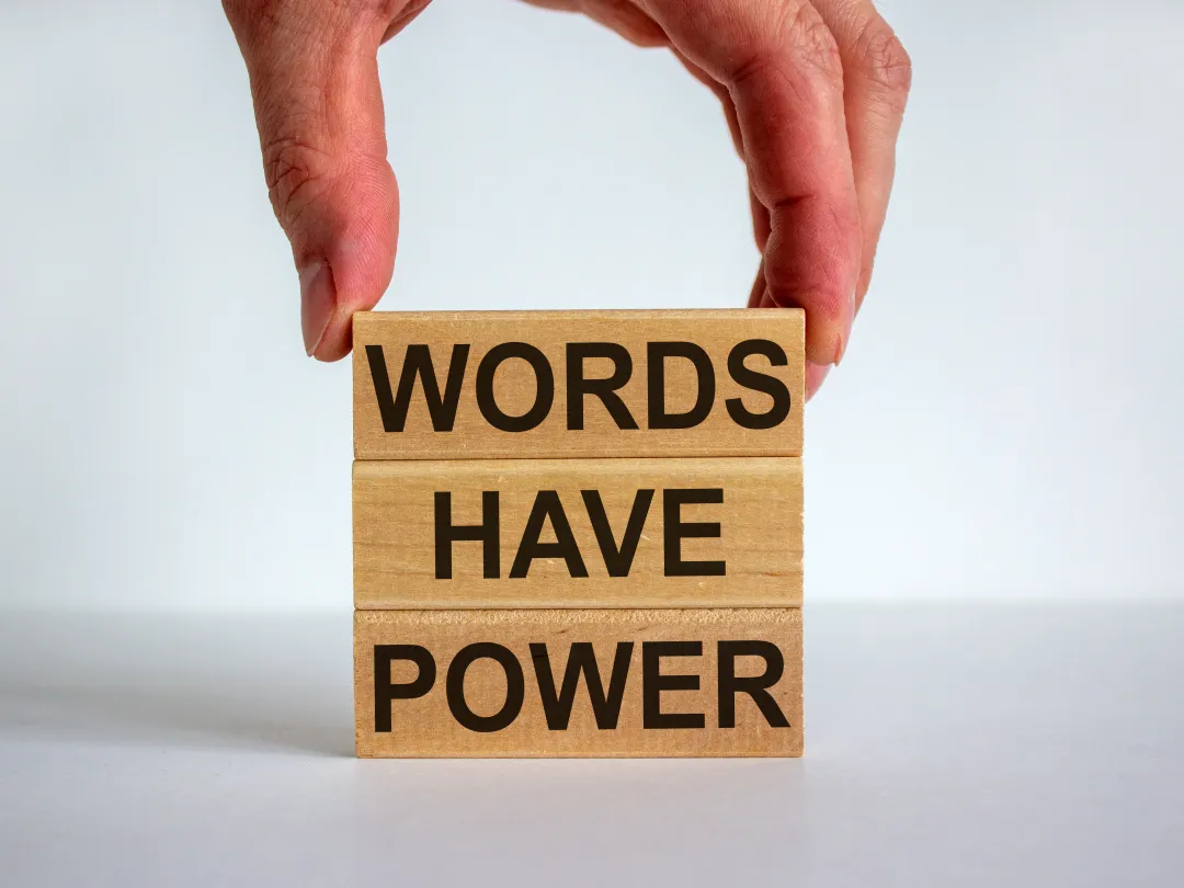 Drie op elkaar gestapelde blokken met de woorden: "Words have power".