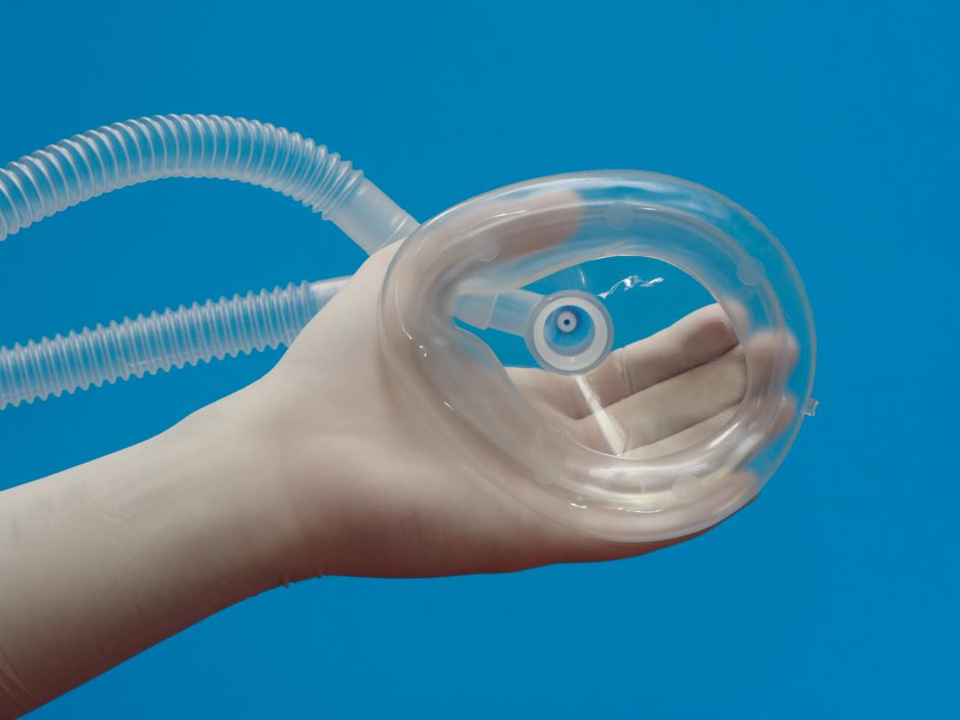 Een kinderhand houdt een zuurstofmasker vast.